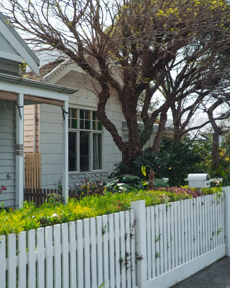 A weatherboard home in the City of Yarra behind a white picket fence